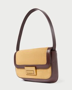 Shoulder baguette bag in hazel tan suede with espresso brown vachetta leather trim. Features slim tonal handles, a push lock closure, full lining, interior zippered pocket, and exterior slip pocket. Brown Baguette Bag With Detachable Handle For Travel, Travel Brown Baguette Bag With Detachable Handle, Brown Baguette Bag With Detachable Strap For Everyday, Luxury Brown Flap Bag With Leather Trim, Everyday Brown Baguette Bag With Detachable Strap, Brown Suede Evening Bag, Elegant Brown Flap Bag With Leather Trim, Timeless Brown Shoulder Bag With Detachable Strap, Elegant Rectangular Flap Bag With Leather Trim