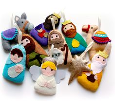 small felt nativity ornaments are displayed on a white surface