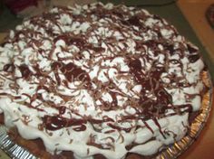 a pie with chocolate and whipped cream on top