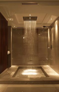 a shower head in the middle of a large bathroom with lights on it's sides