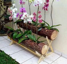 a bench made out of logs with flowers in it