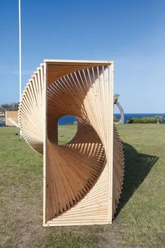 a wooden sculpture sitting on top of a lush green field