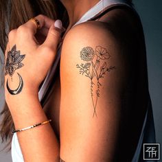 a woman's arm with flowers and a crescent tattoo on the left side of her arm