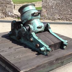 an old cannon sitting on top of a wooden table