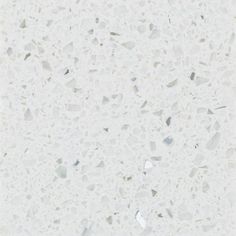 a white marble counter top with lots of small pieces of glass on the bottom and sides