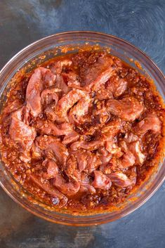 a glass bowl filled with meat and sauce