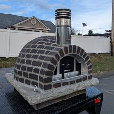 an outdoor brick pizza oven sitting on top of a trailer