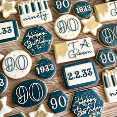 cookies decorated with blue and white icing are arranged on a wooden surface, including the number 90