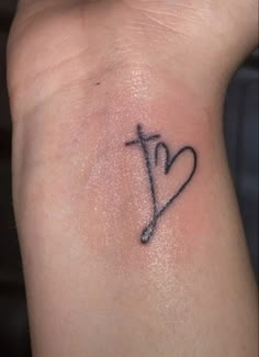 a cross and heart tattoo on the wrist