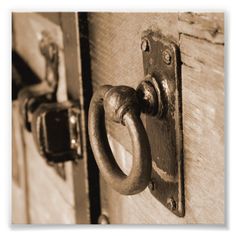 an old door handle on the front of a wooden door with two rings hanging from it