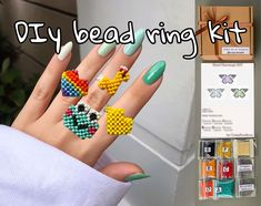 a woman's hand with bead rings on it and some other items in the background