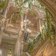 an ornately decorated building with chandeliers and greenery on the ceiling is pictured in this image