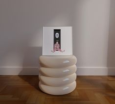 there is a photo on top of a stack of white chairs in the room with wood flooring