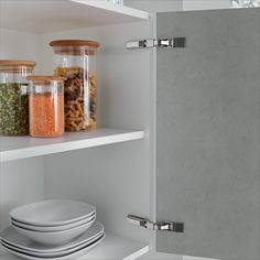 the shelves are filled with different types of food and dishes in glass jars on them