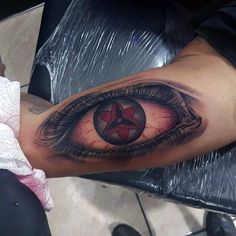 an eye tattoo on the arm with a star in it's center and a pentagramil inside