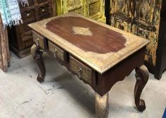 an old wooden table sitting next to other antique furniture