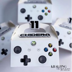 the front and side of a white box with black buttons on it, surrounded by other game controllers