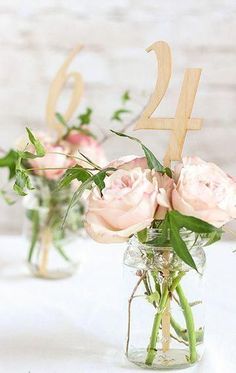 two vases filled with pink flowers on top of a table