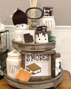 there is a cake stand with cookies and marshmallows in it on the table