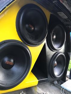 two speakers are sitting in the back of a vehicle's speaker box, with wires running through it