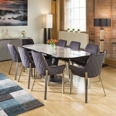 a dining room table with chairs and a rug on the floor