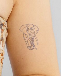 an elephant tattoo on the back of a woman's left arm