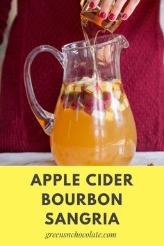 a woman pouring apple cider bourbon sangria into a pitcher