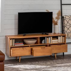 a flat screen tv sitting on top of a wooden entertainment center