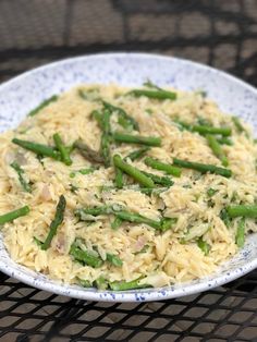 a white plate topped with rice and asparagus on top of a metal grill