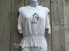 White "Jamaica" T-shirt with cutout shoulders and braided fringe by Sun Island. Summer Short Sleeve Tops With Tassels, Summer Tassel Short Sleeve Tops, Summer Short Sleeve Fringe Top, Casual Summer Fringe T-shirt, Summer Fringe Tops With Short Sleeves, Summer Fringe Short Sleeve Top, Vintage Crew Neck Crop Top For Spring, Spring Vintage Crew Neck Crop Top, Spring Short Sleeve Tops With Fringe