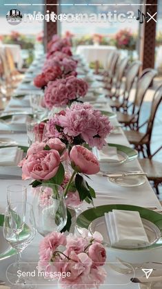 a long table with pink flowers and place settings