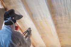 a man in a pirate hat is working on the ceiling inside his tent with tools