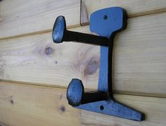 an iron hook on the side of a wooden door with wood planks in the background