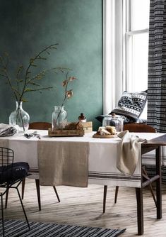 a dining room table with two vases on it and a white table cloth draped over the table