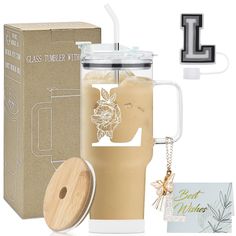 a glass tumbler with a wooden lid next to a cardboard box and keychain