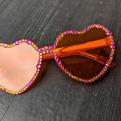 Material of glasses: Plastic Frame color: Orange Rimless Frame Shape: Heart Lens Color: Orange Crystal Color: Pink Flamingo Note: These are fashion glasses. Not intended to protect eyes against strong sunlight.  ✨Every stone is placed by hand and each pair is one of a kind. Individually adorned with dazzling rhinestones, these sunglasses create a radiant sparkle that catches every eye. ✨ 💕Every pair comes with a microfiber pouch to keep your shades safe and can be used for a quick, easy cleanin Multicolor Heart-shaped Sunglasses With Gradient Lenses, Heart-shaped Multicolor Sunglasses With Gradient Lenses, Trendy Multicolor Heart-shaped Sunglasses, Heart-shaped Sunglasses With Tinted Glass Lenses, Heart-shaped Glass Sunglasses With Tinted Lenses, Heart-shaped Tinted Glass Sunglasses, Heart-shaped Glass Sunglasses For Gift, Heart-shaped Glass Sunglasses As Gift, Multicolor Glass Sunglasses As Gift