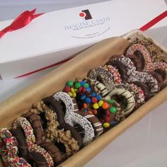 a box filled with lots of donuts covered in sprinkles and chocolate