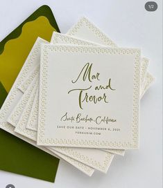 the wedding stationery is laid out on top of green and yellow envelopes for guests to use