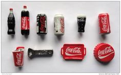 coca - cola bottle openers and keychains are arranged on a white surface