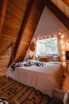 a bed in a loft with lights strung from the ceiling