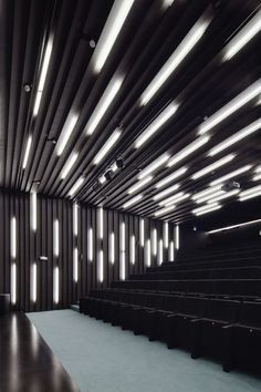 an empty auditorium with rows of black seats