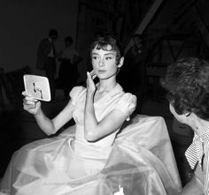 a black and white photo of a woman looking at her cell phone