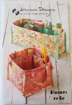 two storage bins sitting on top of a wooden floor with scissors and pens in them