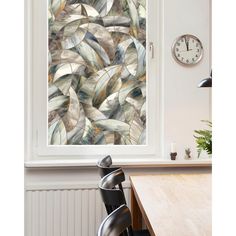 a wall mounted clock sitting next to a window in a room with a painting on the wall