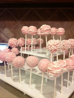 there are many pink and white lollipops on display