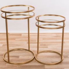 two round gold metal side tables on wooden floor