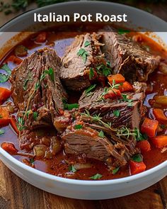 a bowl filled with meat and vegetables on top of a wooden table