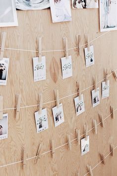 clothes pins and pictures hang on a wooden wall