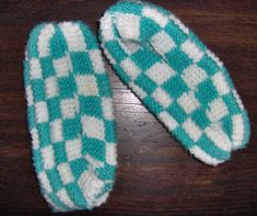 two green and white checkered mitts sitting on top of a wooden table next to each other