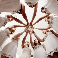 a group of women standing in a circle with their hands together